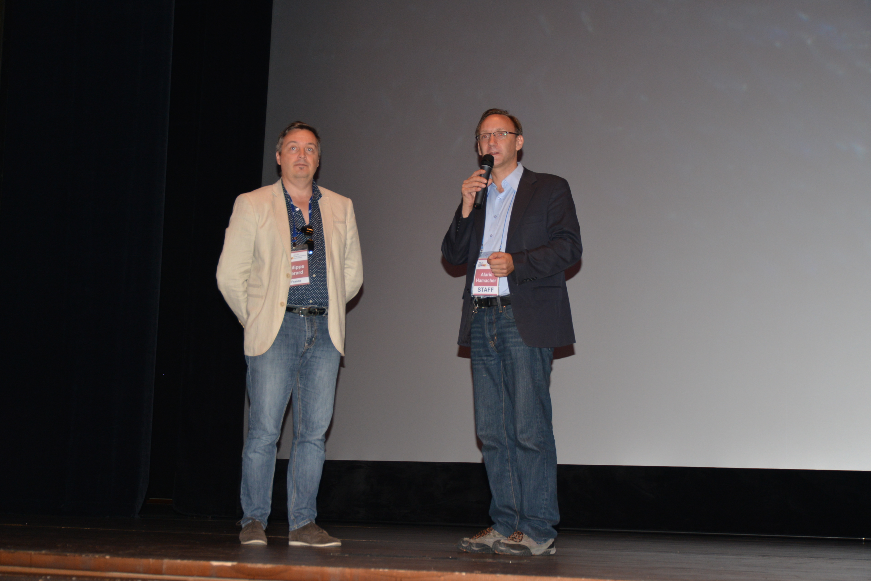 Philippe Gerard and Alaric Hamacher introduce a programme on the cinema stage.